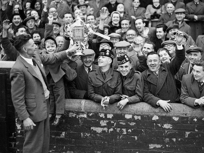 Mathie Chalmers, the Hearts groundsman, shows the Scottish Cup to a section of the crowd at Tynecastle in April 1956. Hearts had beaten Celtic at Hampden Park in the Scottish Cup final.