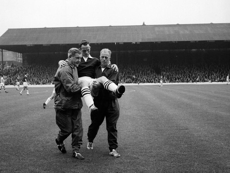 Celtic trainer Rooney and Hearts' trainer Johnny Harvey carry an injured John Cumming off the field during the Hearts v Celtic match in August 1964.