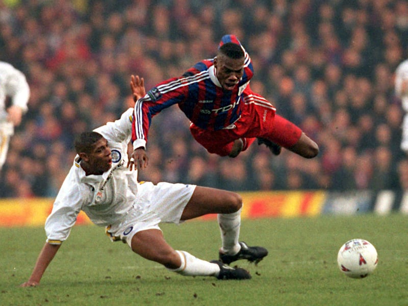 Crystal Palace's George Ndah takes a tumble over the leg of Carlton Palmer during the FA Cup third round replay at Elland Road. The Whites won 1-0.