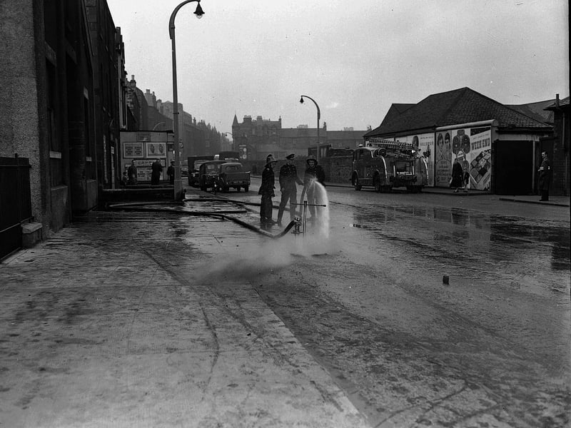 Firemen wash away highly flammable paraffin oil which flowed onto Dundee Street after a fire at at the North British Rubber Mills plant in Fountainbridge in May 1960.