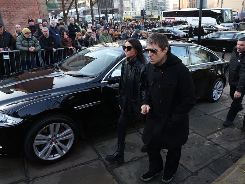 Oasis singer Liam Gallagher arriving at the funeral alongside partner Debbie Gwyther.