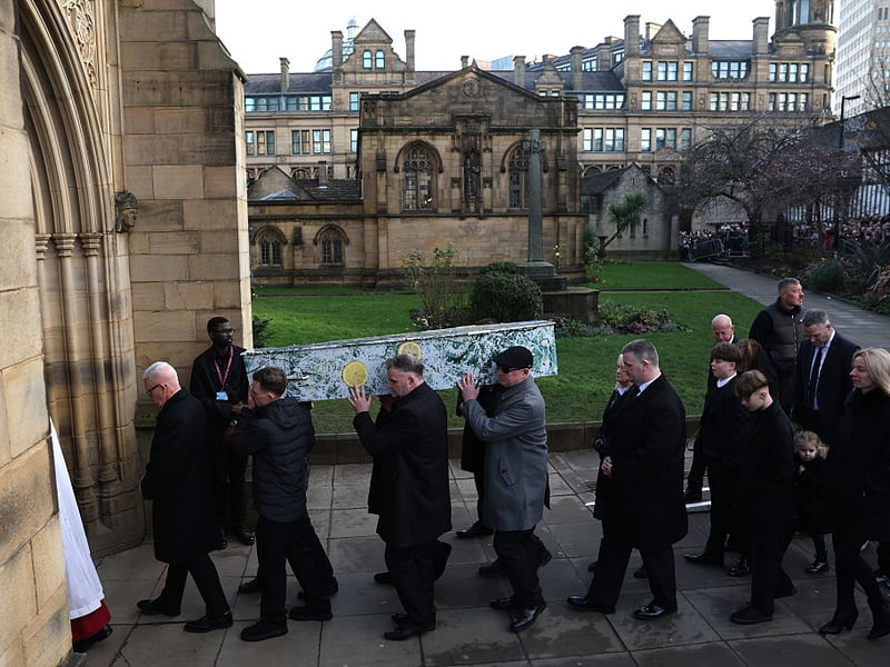 The coffin is carried into Manchester Cathedral.