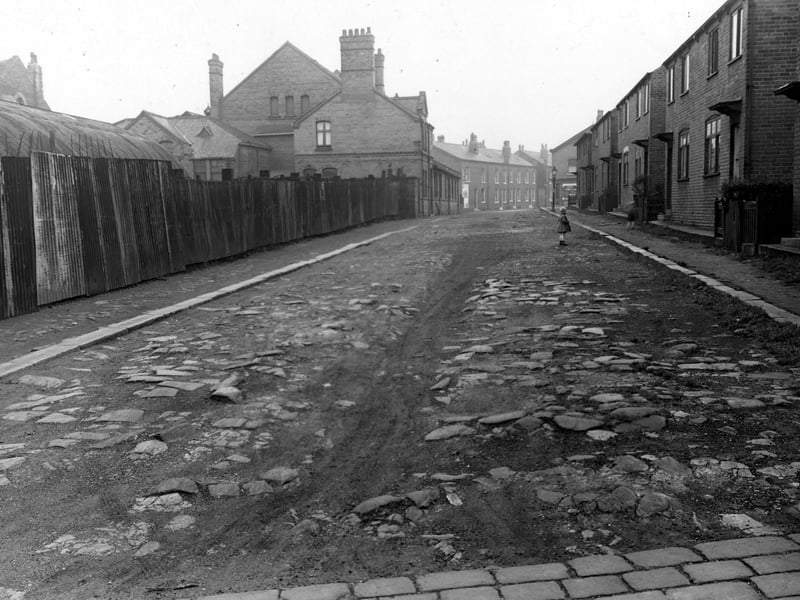 Hall Place in November 1953. Children play on the road, which is unmade and stony.