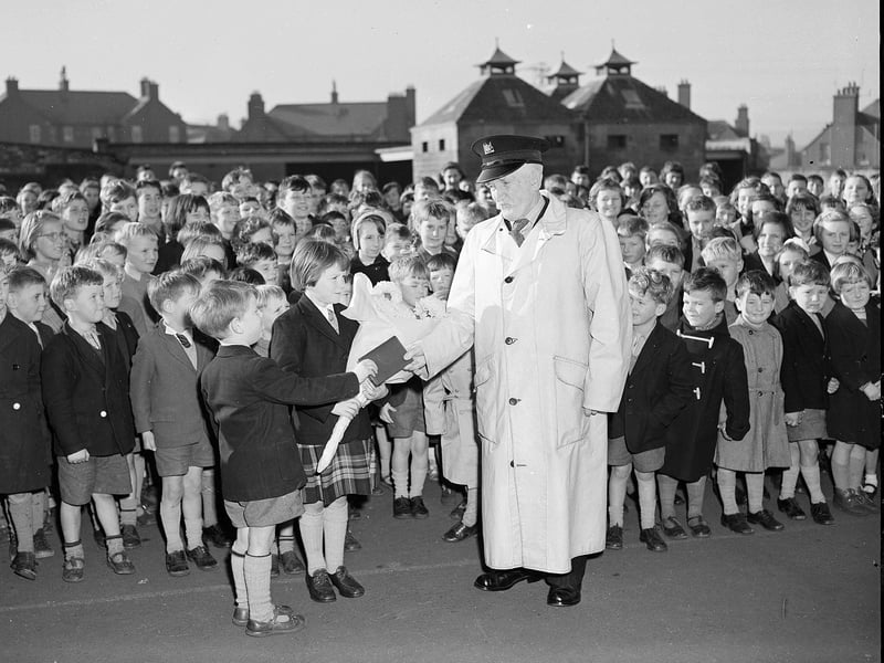 Gilmerton School janitor James Sim is presented with a wallet by pupils to mark his retirement in October 1958.