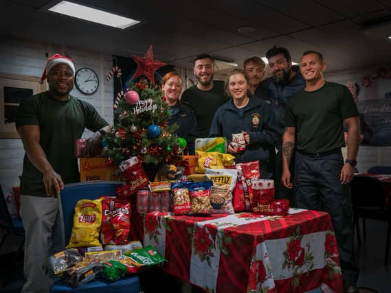 Personnel aboard HMS Medway receiving Christmas presents and donations from the RNRMC.