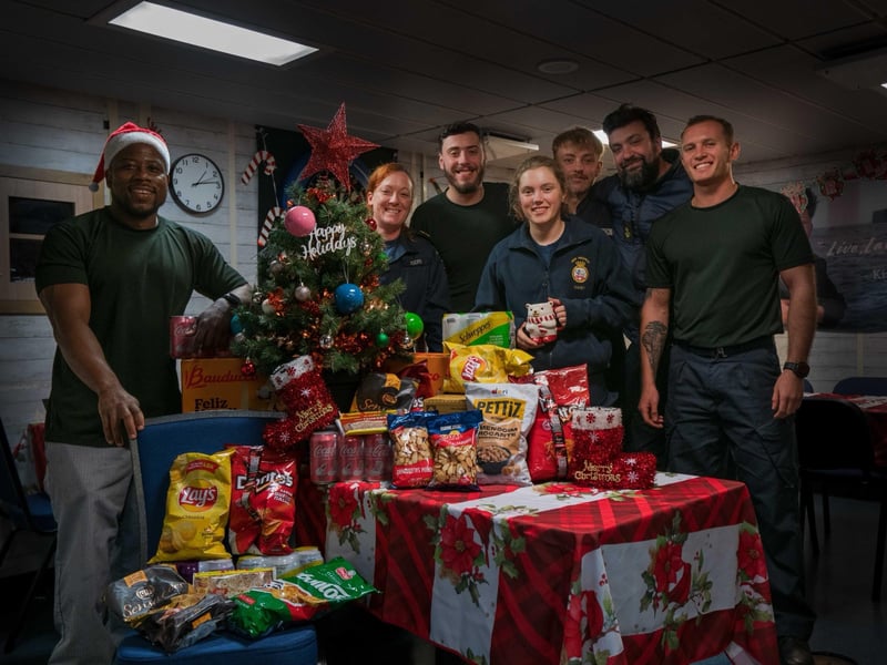 Personnel aboard HMS Medway receiving Christmas presents and donations from the RNRMC.