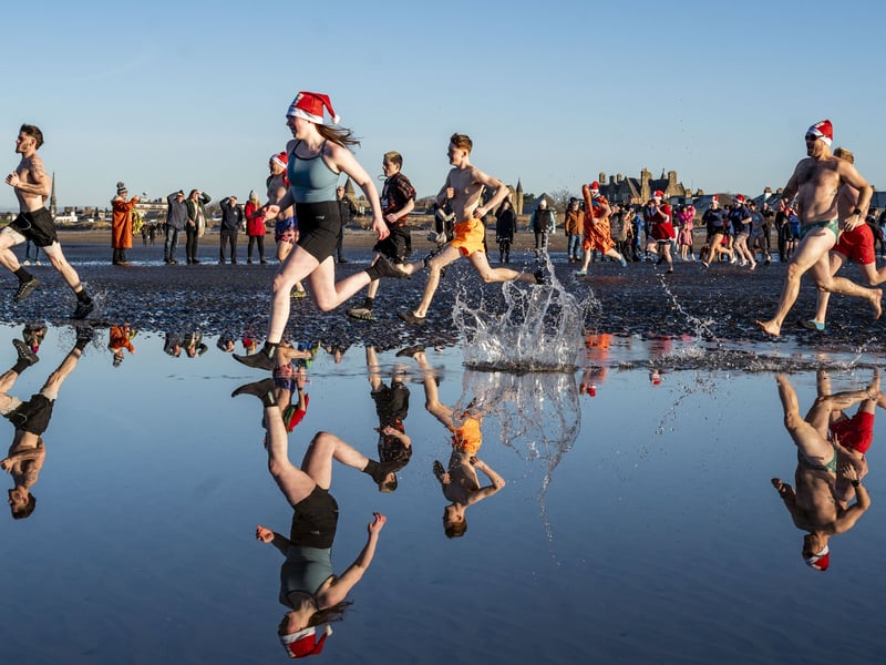 The swimmers raced into the freezing cold sea 