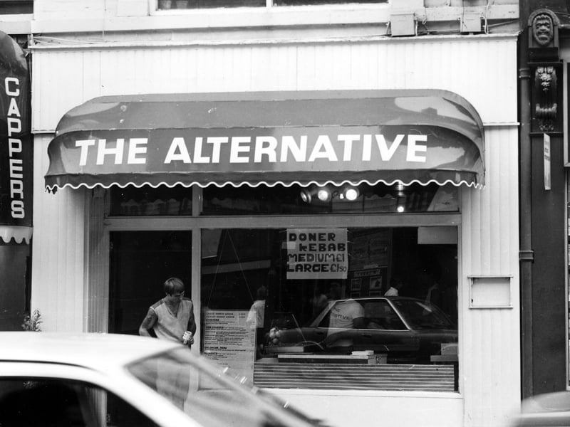 The Alternative restaurant and take-away at no 31 New Briggate in August 1984. Doner kebabs are advertised in the window at £1.00 for a medium one and £1.50 for a large; there is a full menu lower down. A man is standing by the door.