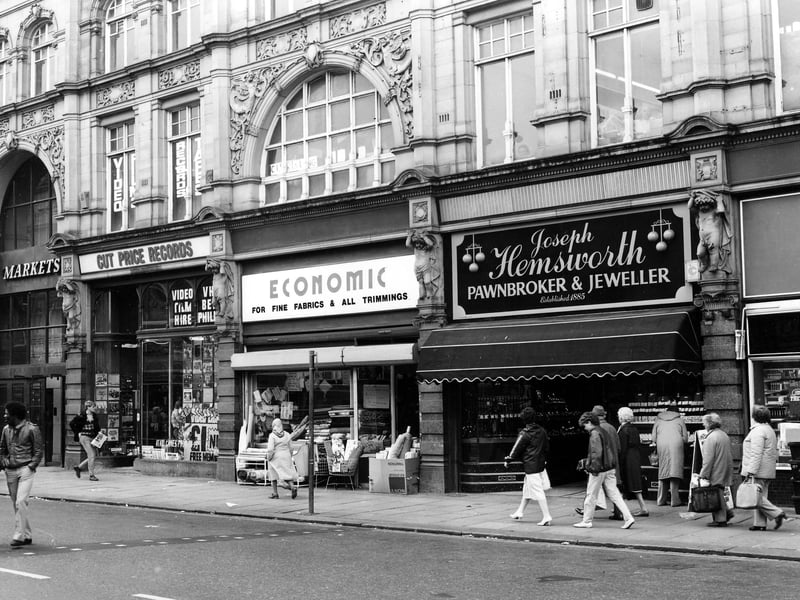 Kirkgate Market from Vicar Lane in May 1984. On the left is the Market Hall entrance, then Cut Price Records, no.13 Market Buildings, Economic Woollen Company, fabrics, no.14 and Joseph Hemsworth, jeweller, no.15.