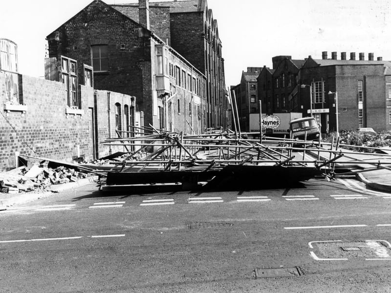 David Street looking from Manor Road in July 1986. On the left, demolition is taking place of nos.39-41 David Street, blocking off the road in the process. On the right is a cleared area where St. Francis' R.C. Church and St. Joseph's R.C. Secondary School once stood. Behind this is a department of the Leeds Industrial Co-operative Society.