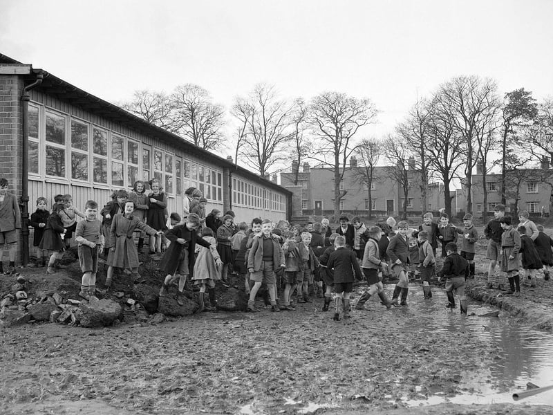 Children playing in mud during their morning break at Broomhill School in October 1952.