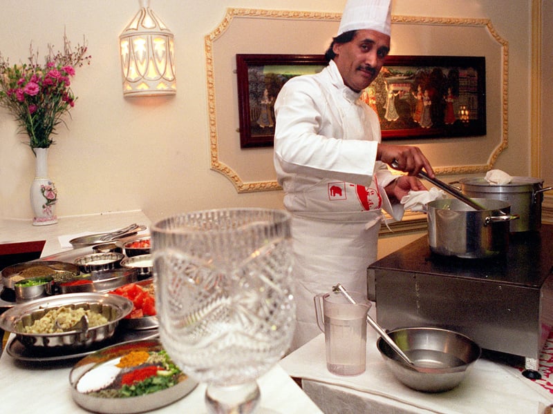 Mohammed Aslam who had won the International Indian Chef of the Year contest , pictured cooking at the Aagrah restaurant with his trophy in the foreground.