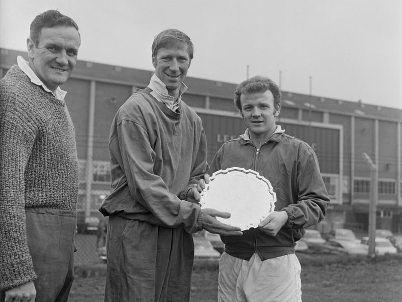 Leeds United players Jack Charlton and Billy Bremner hold a prize, as manager Don Revie looks on, at Elland Road, in December 1969