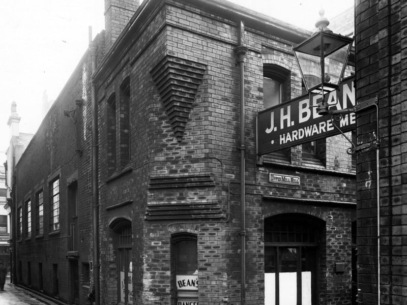 Looking along Albion Walk in November 1950 past J.H. Bean plumbers merchants on Upper Mill Hill. Miles and Mountford fancy leather goods dealers is partially visible on Albion Street.