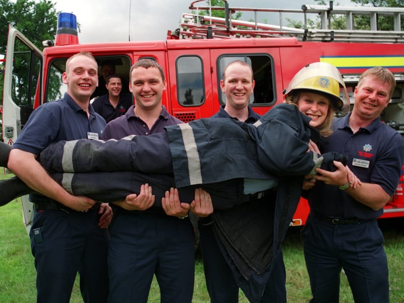 A fireman's lift for TV weather girl Debbie Lindley when she officially opened the 1st Annual Gala & Craft Fair of the Huddersfield & Kirklees Branch of the Multiple Sclerosis Society at Marmaville Country Club in July 1999. The Mirfield Fire Station firefighters are, from left, Dave Small , Chris Lenaghan , Dave Wilmot and Richard Rhodes.