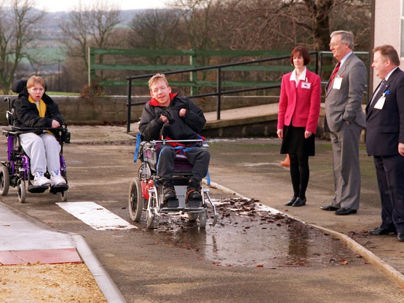 Pupils at Holly Bank School try out the new test drive circuit for their wheelchairs which stimulates outside conditions of curb heights, puddles and uneven flagstones in December 1997.