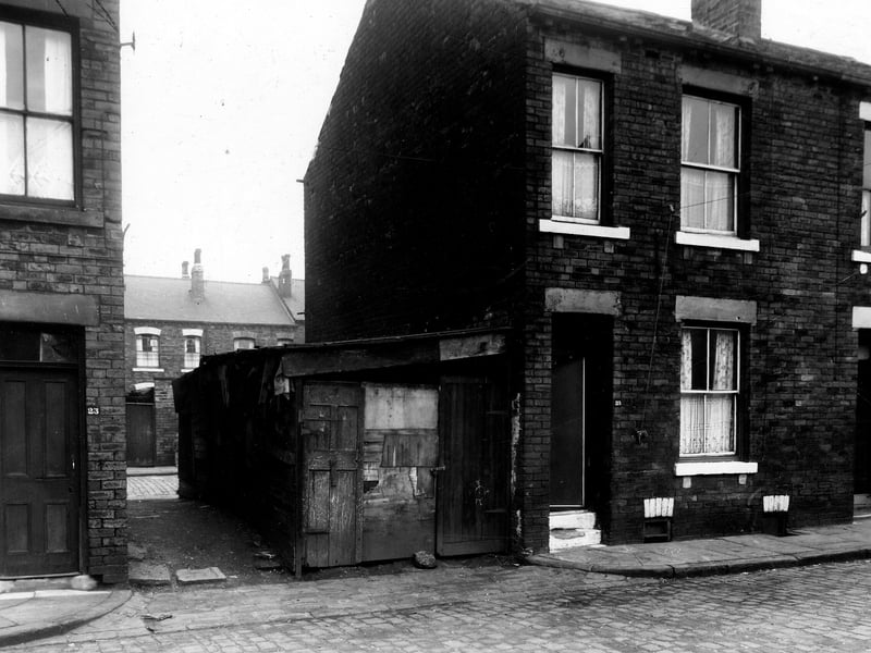 Number 23 Metcalf Street is on the left, 25 to the right. In the gap between the houses a shed made from old doors can be seen. Thornton Street is visible behind the shed. Pictured in November 1959.