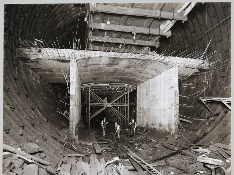 Workers standing in the bottom section of the Queensway Tunnel, Liverpool, in September 1929, beneath an experimental length of reinforced concrete, which would form the roadway.