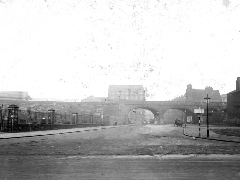 Duke Street in November 1931. Fenced off land to left, railway bridge runs along length of the centre of the picture. Horse and cart on right road. Empty area of land to right where a row of buildings were previously demolished.