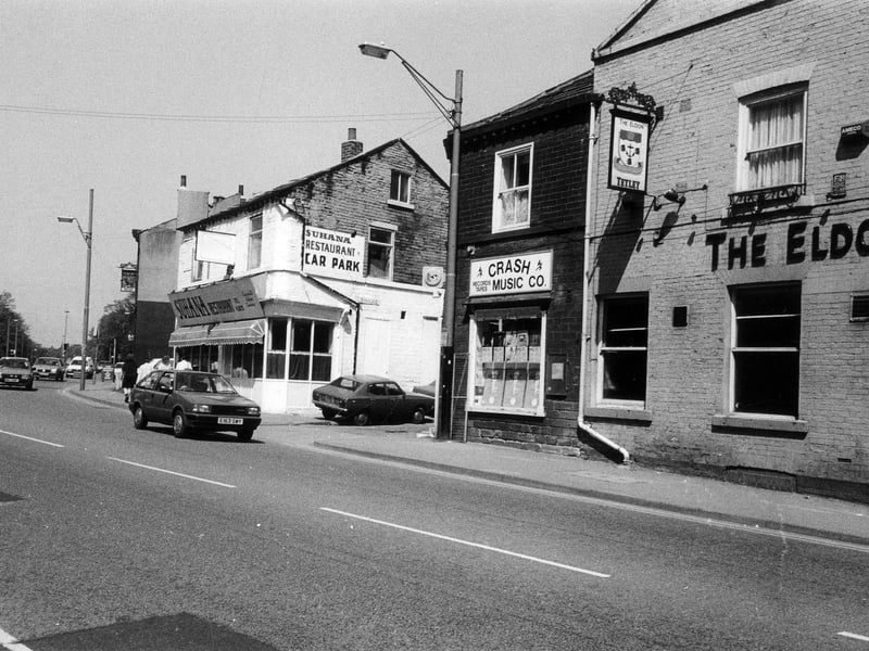 Looking north-west along Woodhouse Lane. The Eldon public house is on the right followed by Crash Music Co. The junction with Spenceley Street is next then the Suhana Restaurant. Further along is the Pack Horse public house.