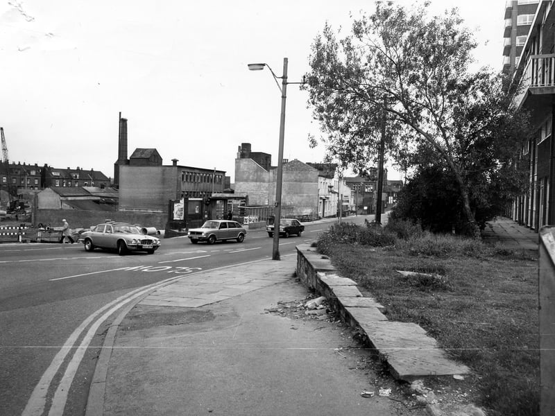 Armley Road looking east, seen from the junction with Crab Lane in September 1980. The white-fronted building in the centre is the Nelson public house. On the left is a building site, in which a crane can be seen. On the right is a block of housing.
