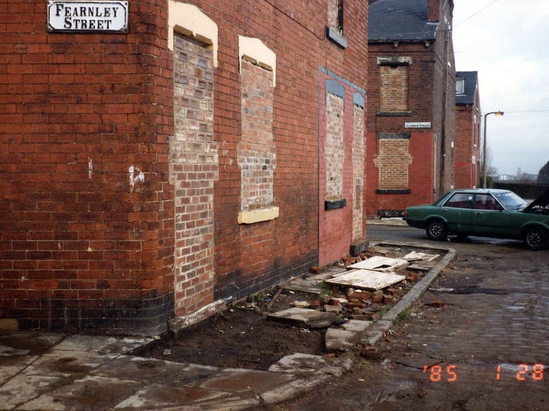 A corner of Fearnley Street pictured in January 1985 prior to demolition. Windows and doors have been bricked up and the pavement has been dug up. The next row of houses is Gledhow Street. These two streets were part of series of long streets which ran between Hall Lane and Tong Road.