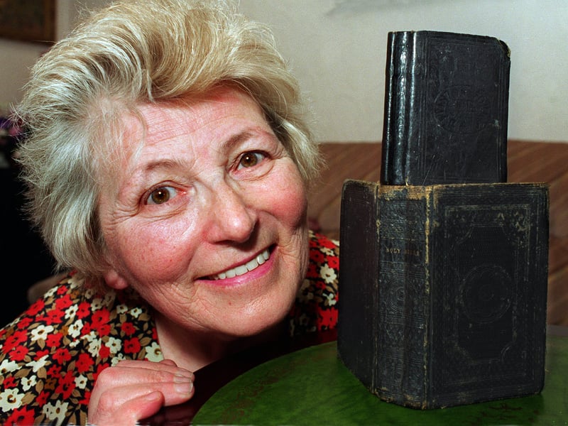 This is Kathleen Green pictured with two bibles that belonged to her relatives in the 19th century.