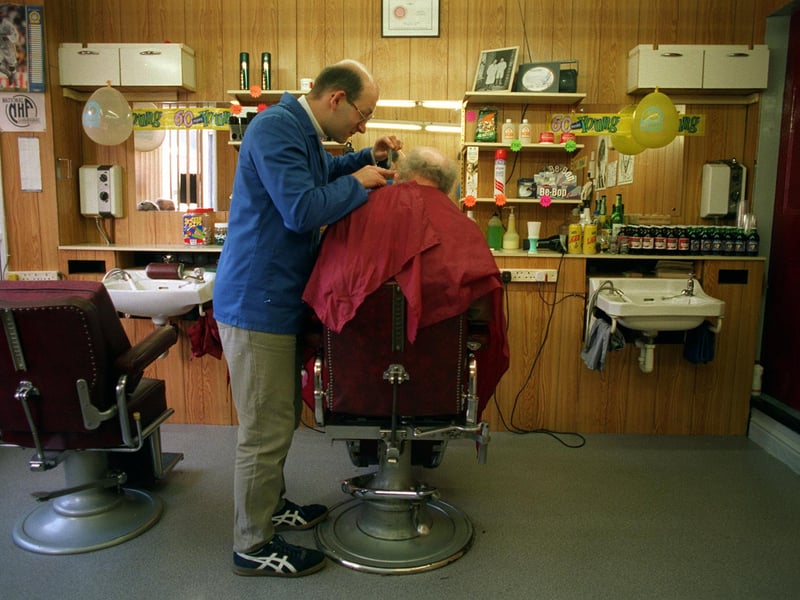 David Miles of Malcolm's Barbers gives a haircut to Len Myers who had been a customer at his shop for 55 years.