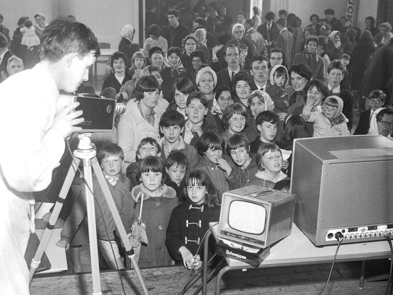 The crowd see themselves on TV as they are filmed at the May Fair in Pilton in May 1966.
