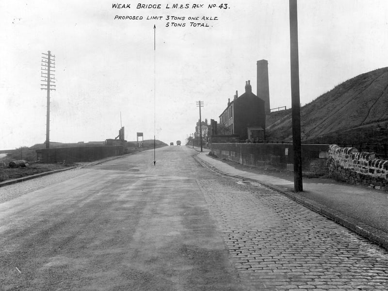 Gelderd Road at the point where it crosses the London Midland and Scottish Railway. A City Engineer's note says "Weak Bridge LM&S Rly No. 43. 3 tons one axle 5 tons total". On the right is part of the disused Ravells Pit and a row of three terraced houses, with a chimney behind belonging to a chemical works. Pictured in September 1935.