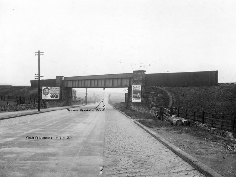 The railway bridge running over Gelderd Road in October 1935. On the left hand side is a big billboard for Oxo with a big picture of Henry VIII and the message; 'Henry VIII had six wives - your home comfort is Oxo.' Bridge has a minimum headroom of 15'-10". Billboard on the right says; 'Marsh's Sausages - The World's Best.'