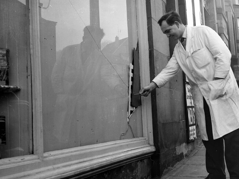 Inpecting the damage done to a grocer shop on Blackford Avenue targeted by robbers in December 1962.