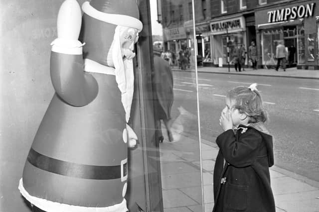 A little girl stops to admire the inflatable Santa Claus in the window of Blyth's department store, Earl Grey Street, Tollcross, in August 1964.
