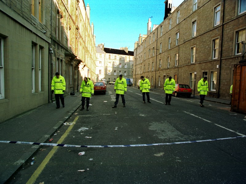 Police officers walk in a line on Drumdryan Street as they hunt for bullets after a shooting alert in Tollcross in October, 1997.