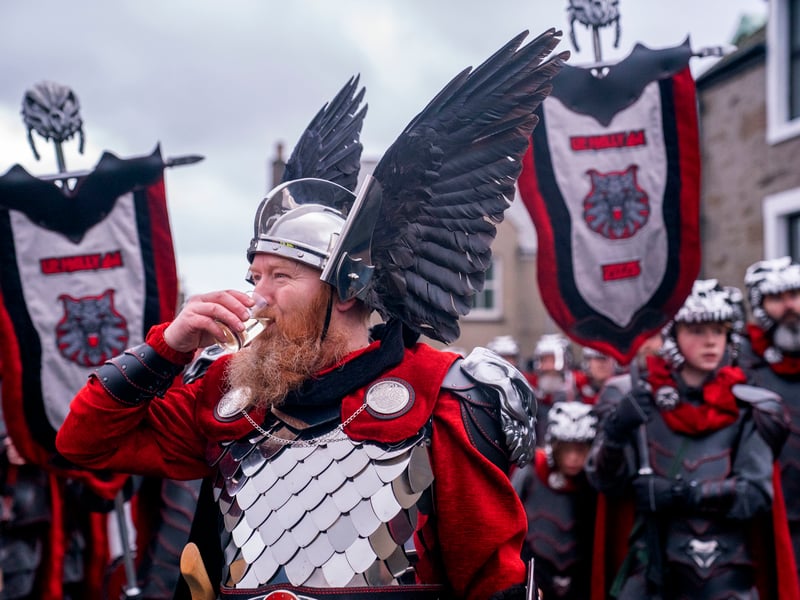 Lynden Nicolson, the Guizer Jarl of the Jarl Squad has a dram of whisky during the parade through Lerwick.
