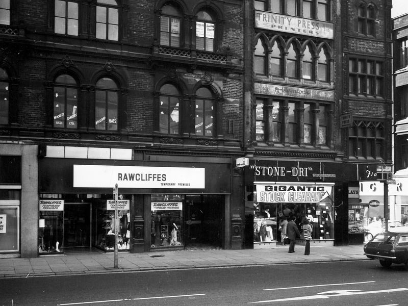 Boar Lane in the mid-1970s showing nos. 11 - 13. No. 11 is the temporary premises of Rawcliffes clothiers, whose Duncan Street store is in the middle of a major renovation. At no. 12, Stone-Dri weather is promoting a 'gigantic stock clearance'. No.13 on the corner with White Horse Street is Finlays tobacconist. Just visible on the right hand edge is the Singer Sewing Machine Co. Ltd. at no. 14.