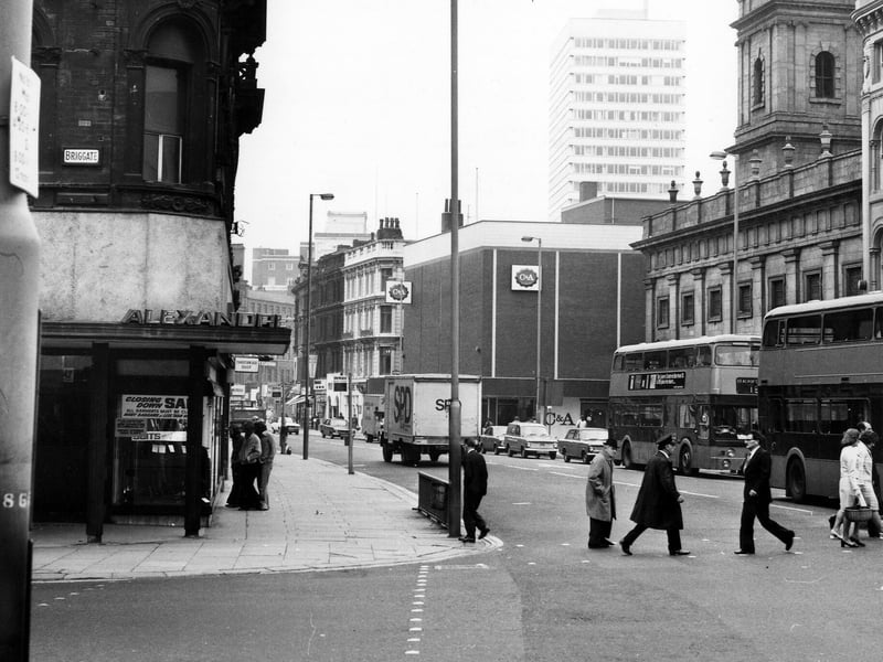 Boar Lane looking west, from the junction with Briggate on the left. Alexandre Menswear on the corner is advertising a closing down sale. On the right are Holy Trinity Church and C & A, with Royal Exchange House seen behind. Taken in the mid-1970s.
