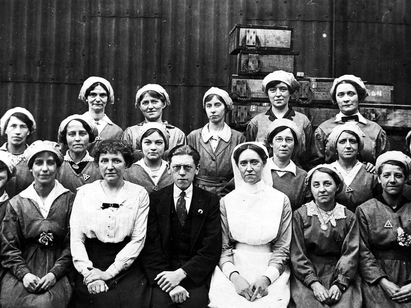 This undated photo shows a group of women workers who were employed at Barnbow, between 1915 and 1918. On the front row a woman in civilian dress, a man and a nurse.