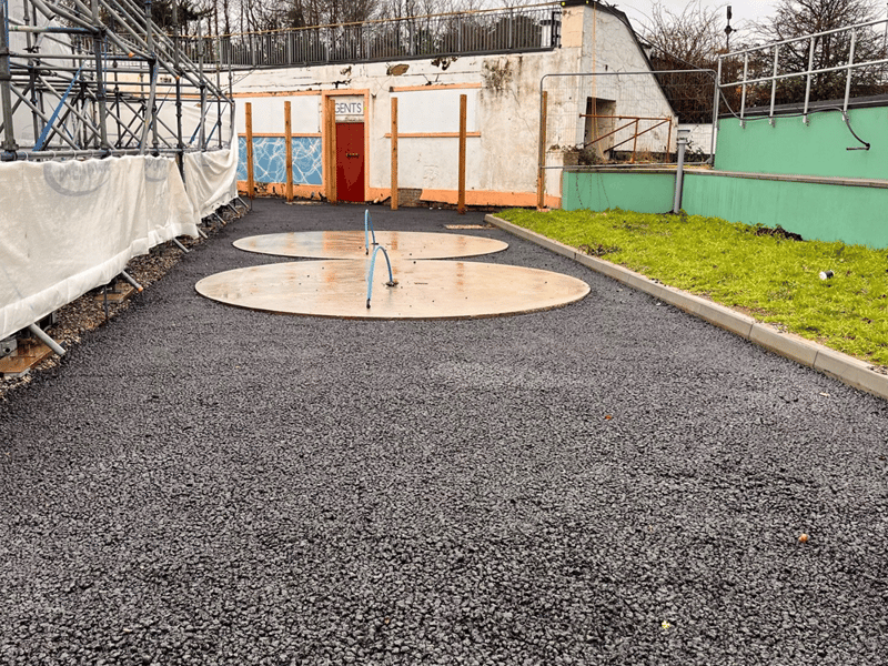 Tarmac has been applied by one of the outdoor shower bases at the outdoor pool.