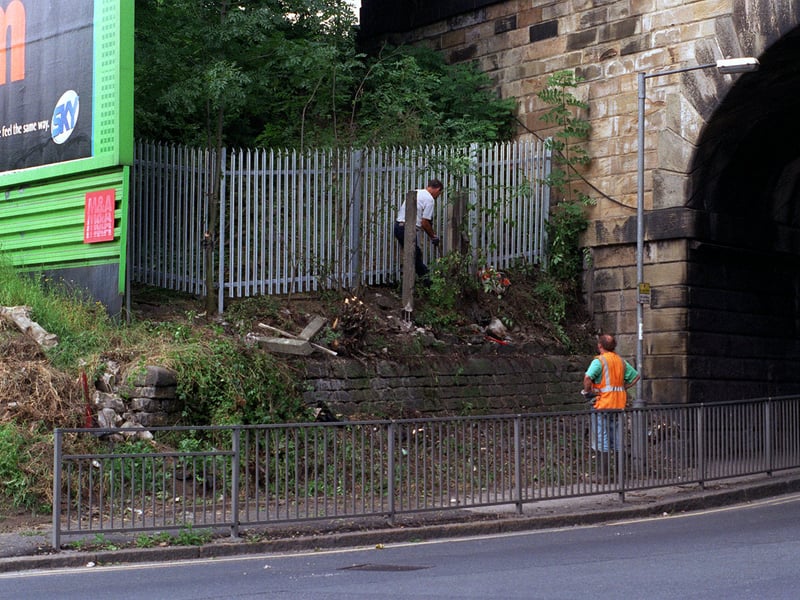 August 1997 and workmen are pictured putting up a a fence and clearing trees near to the railway bridge crossing the A63 Whitkirk-Selby road aimed at stopping youngsters who had been seen throwing stones from the bridge at cars.