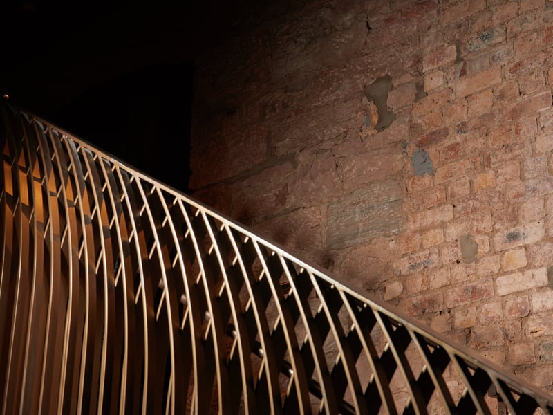 Exposed original brickwork and custom
railings in the new social space to the rear of the building.