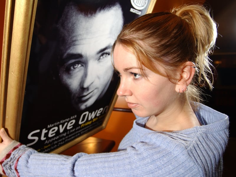 Sarah Braithwaite walks out of Time nightclub, on Frederick Street, Edinburgh, with one of the Martin Kemp (Steve Owen in Eastenders) posters in March 2002