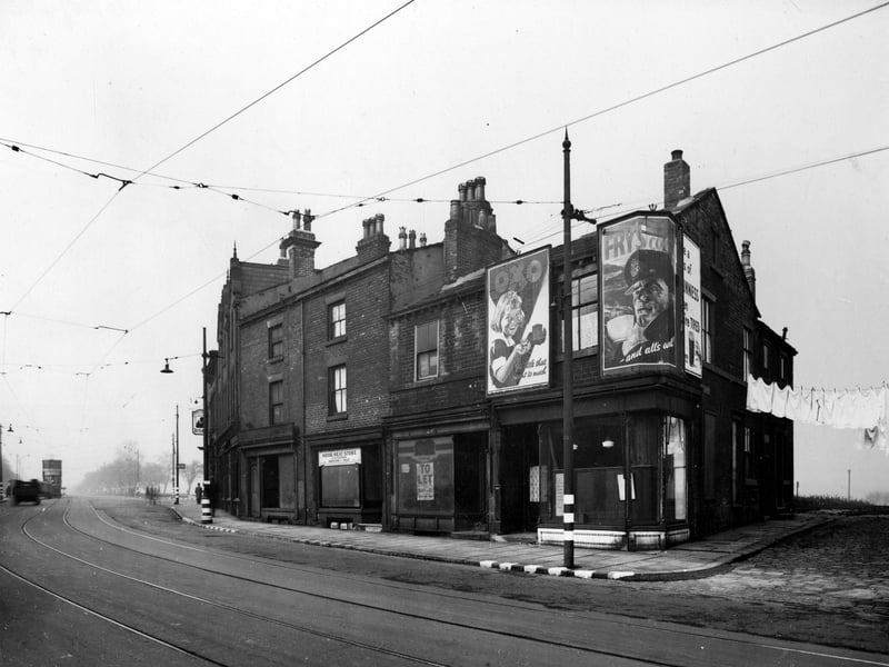 Woodhouse Lane, north east side, nos. 194-210. Tetley pub sign outside Pack Horse public house. Woodhouse Moor in background with tram. Black out markings on kerbs and lamp post. Advertising boards for Oxo, Frys Cocoa and Guinness. Pictured in October 1942.