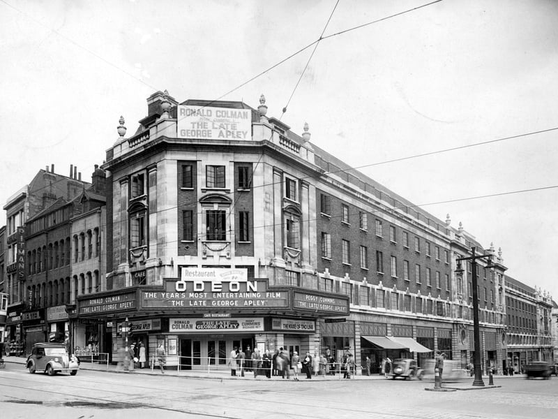 The Odeon Cinema on The Headrow in June 1947. The film showing is 'The late George Apley' and outside there are people meeting, there is a cinema doorman, newspaper sellers and two people talking to a policeman.