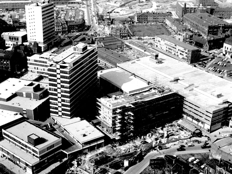 Merrion Centre under construction in April 1965. Merrion Street in bottom right corner. Woodhouse Lane runs past the front, corner of Cookridge Street, Civic Hall car park, which can all be seen on the left. In the top right corner, clothing factory of J.Hepworth and Son Ltd.