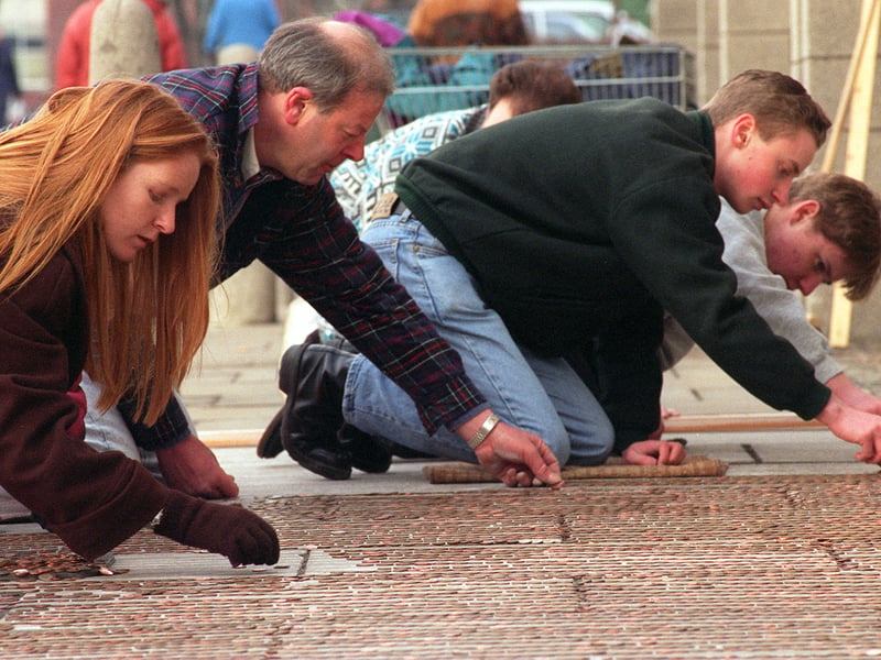 Members of the Rotaract Club of Cleckheaton take part in the laying of a mile of pennies at Tesco's car park in March 1996. It was part of the national Rotaract campaign to 'do something for a mile' to raise £100,000 for the training and supply of a MacMillan Cancer Care Nurse.