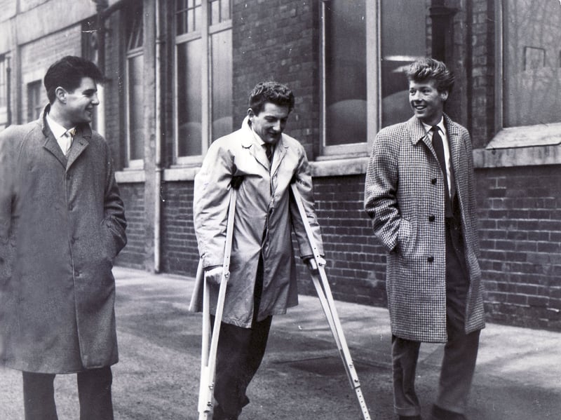 Sheffield Wednesday player Douglas McMillan, who lost a leg in a coach crash on Boxing Day 1960, visits the club's Hillsborough stadium on crutches with two of his pals, Billy Griffin (right) and Graham Birks (left), in January 1961