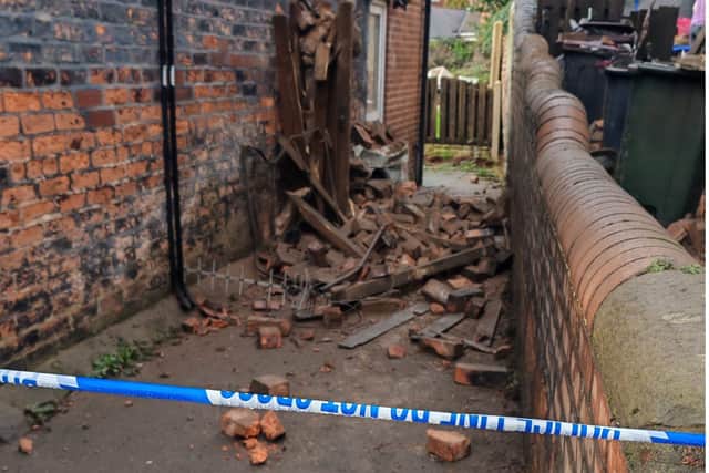 Rubble can be seen in an alleyway between the two properties this morning