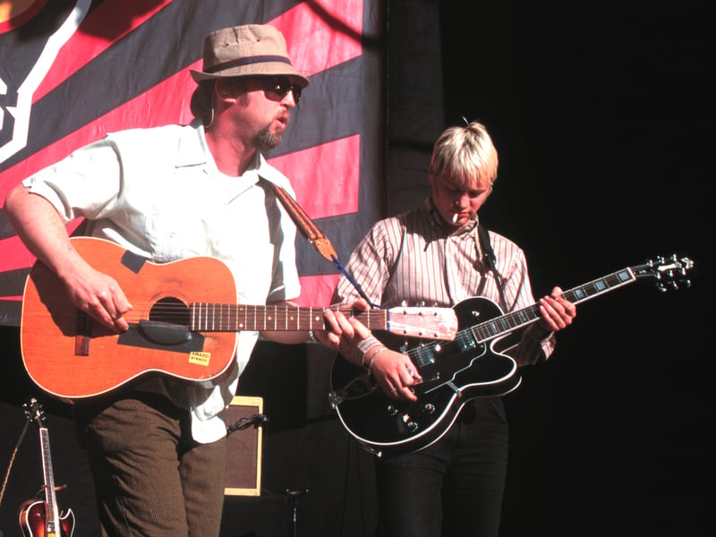 Greg Brown (right), founding member of rock band Cake died after a 'brief illness'. He is pictured with bandmate John McCrea performing in 1999. Image by Tim Mosenfelder/ImageDirect