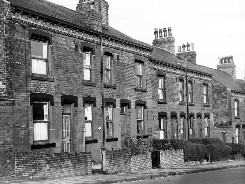 This early 1970s photo shows a row of double fronted back-to-back terraced houses on Winchester Road flanked by yards housing shared outside toilet blocks. Each house has a small private garden at the front of the property. These houses are located opposite the H.M. Armley Gaol.